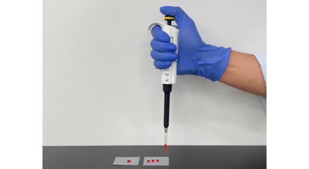 ピペットと試験管と一緒に働く科学者の手。 遺伝子研究所の技術者。 医学研究の旗