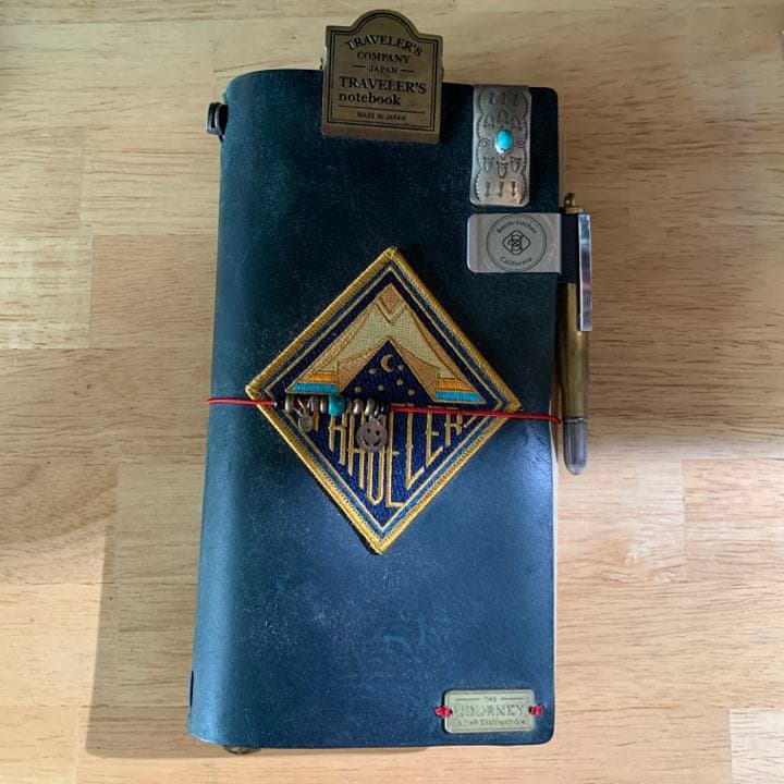 トラベラーズノート オーダーメイドスタンプ お客様のトラベラーズノートカスタマイズのご紹介スタンプの配置センスが抜群だったお客様。レギュラーサイズのBLUEに、 外側は ・ワッペン ・オリジナルスタンプ ・Brass Tag ・星形のコンチョ で。 内側のブラウンの