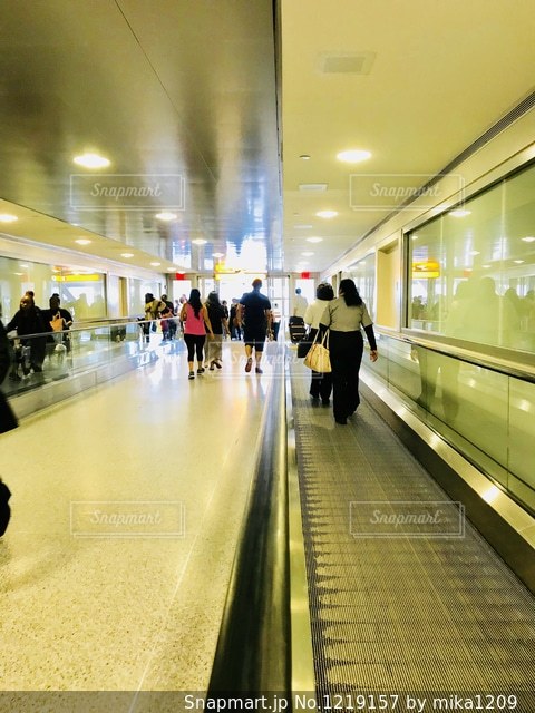 非常に大きい空港で歩くことのエネルギーを節約するためにまっすぐ方向エスカレーターを使用することを許可する緑色の記号の写真素材・画像素材 Image87581008